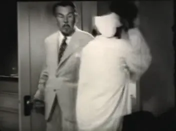 Charlie Chan arrives at the beach house — the detective enters after the initial chaos