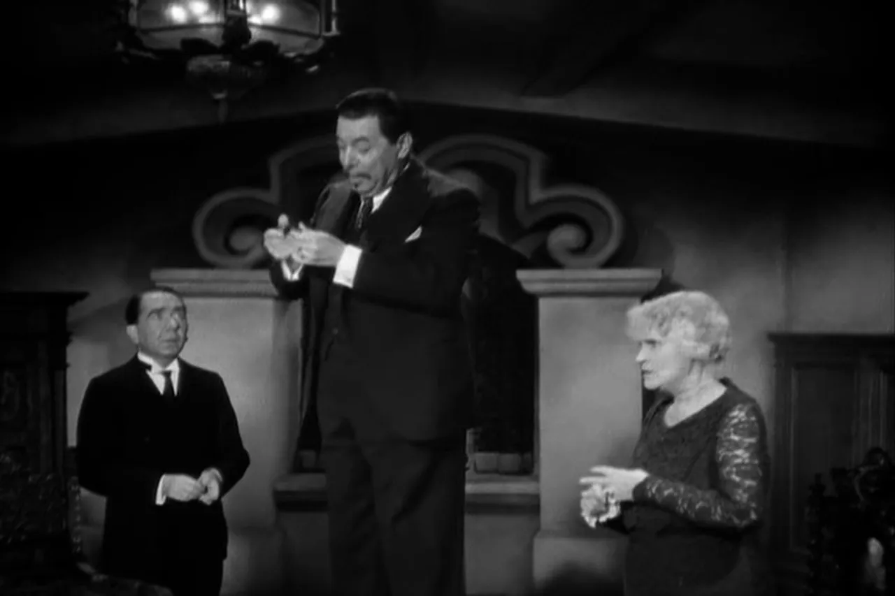 Charlie Chan examines a radio speaker hidden in the house