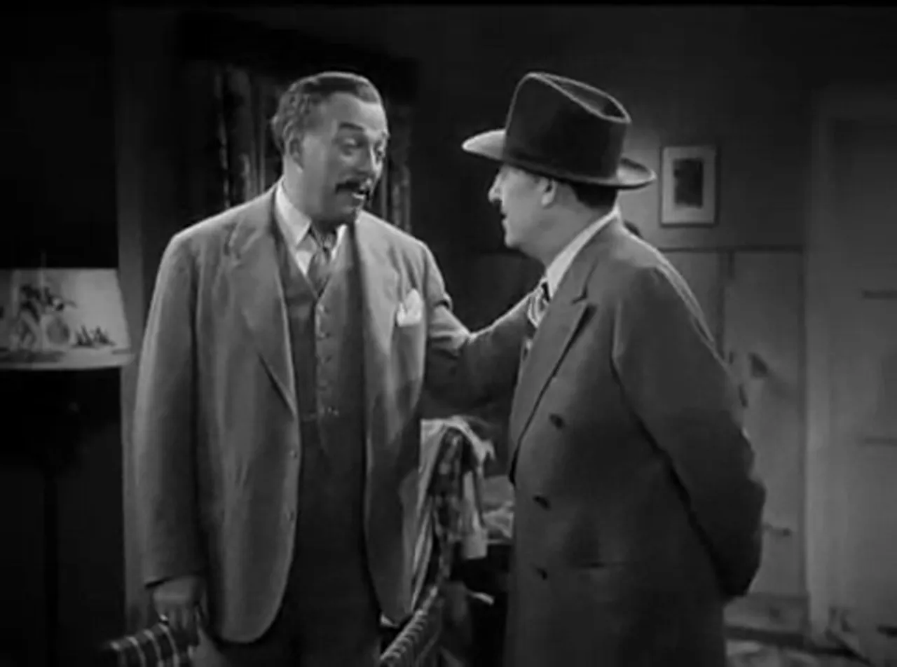 Charlie Chan consults with friends in the ranch lobby about the mine