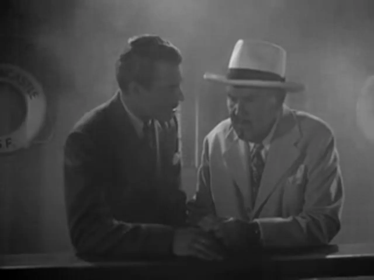 Scott Pearson confides in Charlie Chan about stolen currency, close-up of Sidney Toler at the ship's saloon