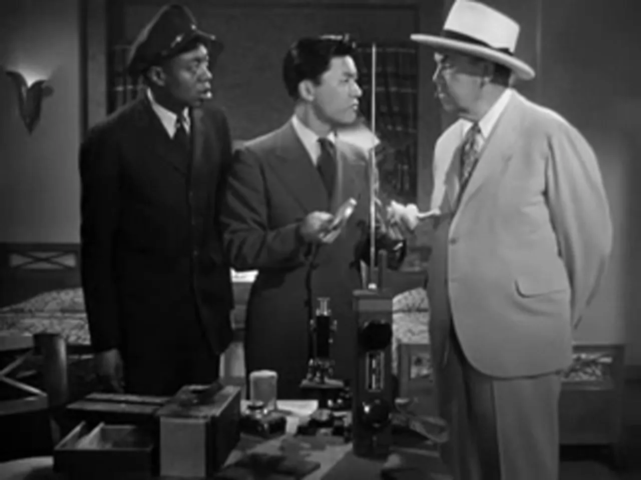 Fingerprinting experiment aboard ship; Chan and crew examine the knife handle