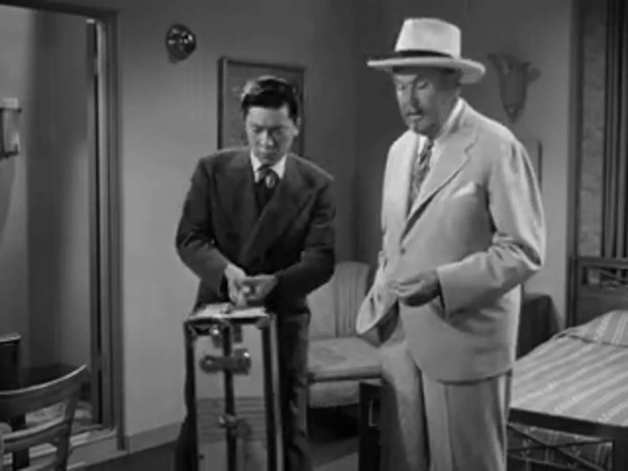 Jimmy Chan and Chattanooga Brown confer with Charlie Chan in the cabin, planning the investigation