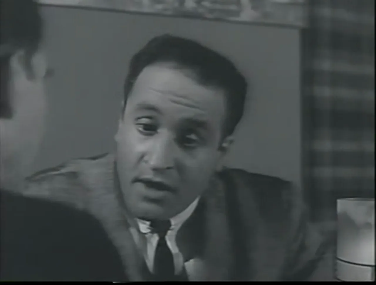 Conspiratorial planning in a cafe: Dorella lays out the five-minute plan; the film noir movie thrives on procedure.