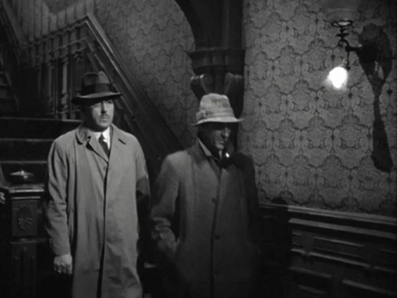 Sherlock Holmes (Basil Rathbone) listening to Inspector Gregson describe the fourth murder