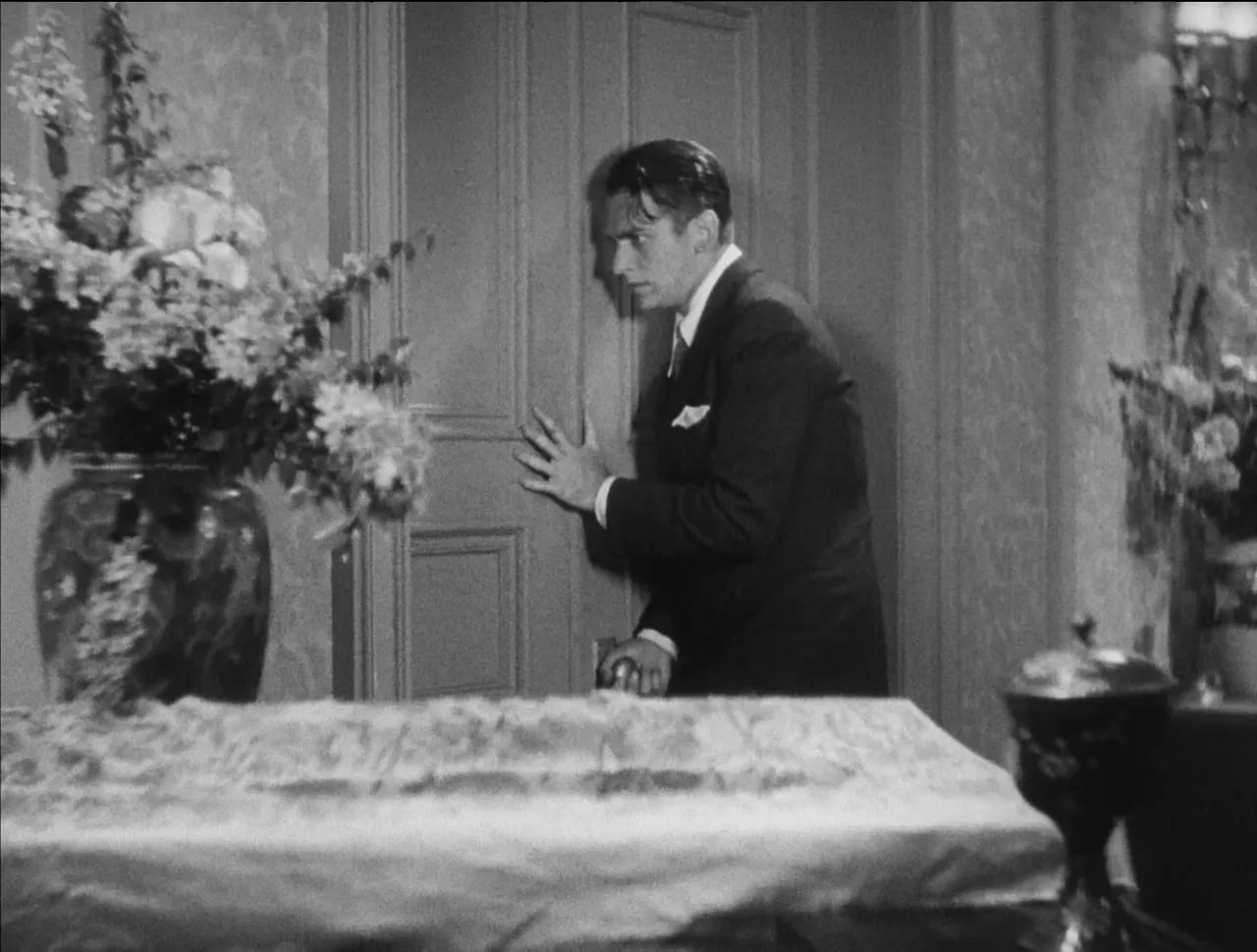 Little Caesar black-and-white scene of a suited Rico standing beside a bed in a flophouse